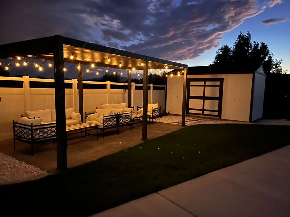 Cozy outdoor seating area with lights, set against a twilight sky. Perfect for relaxation.